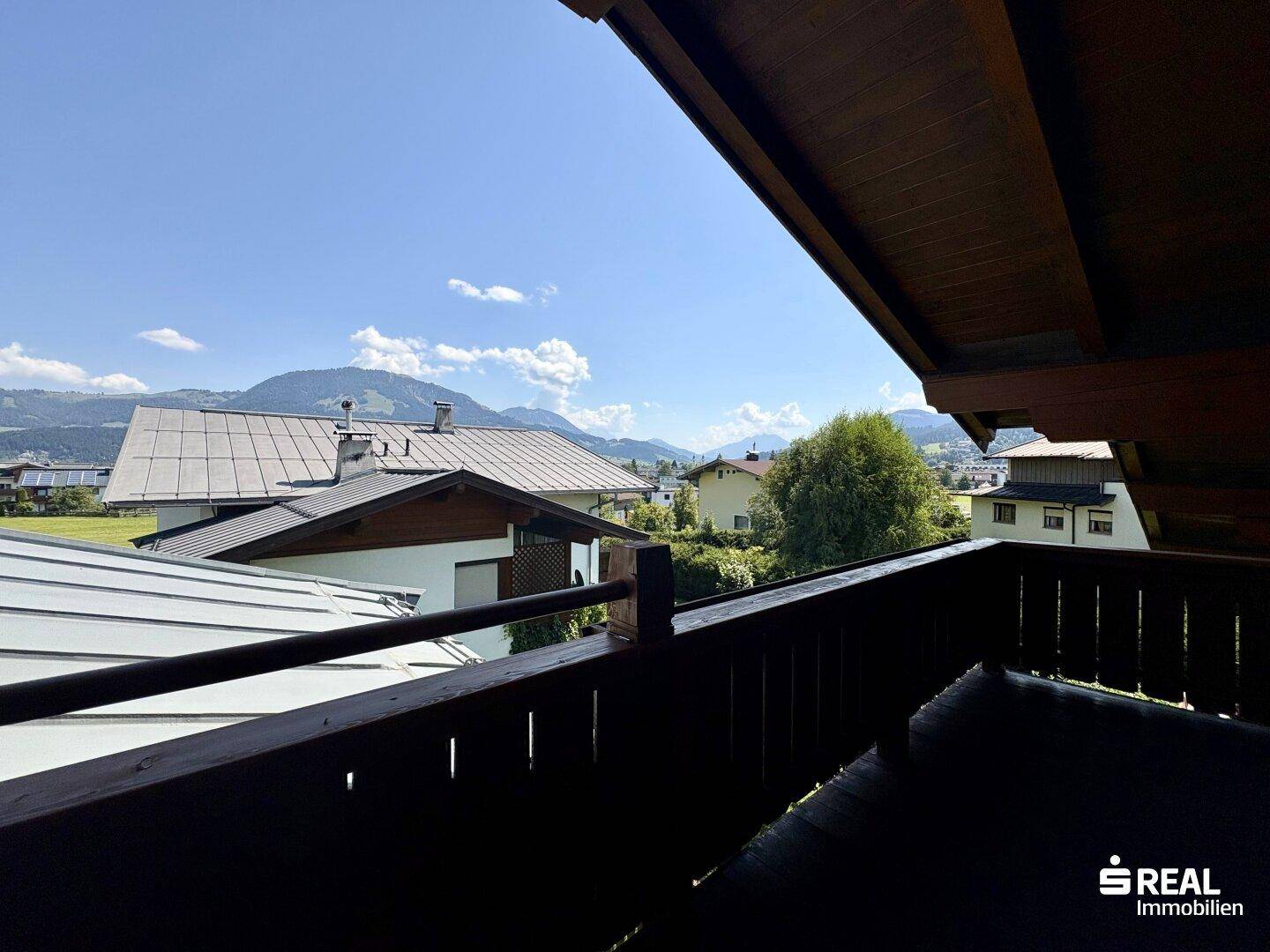 Panoramablick vom Balkon auf die umliegende Wohngegend und die majestätischen Berge im Hintergrund.