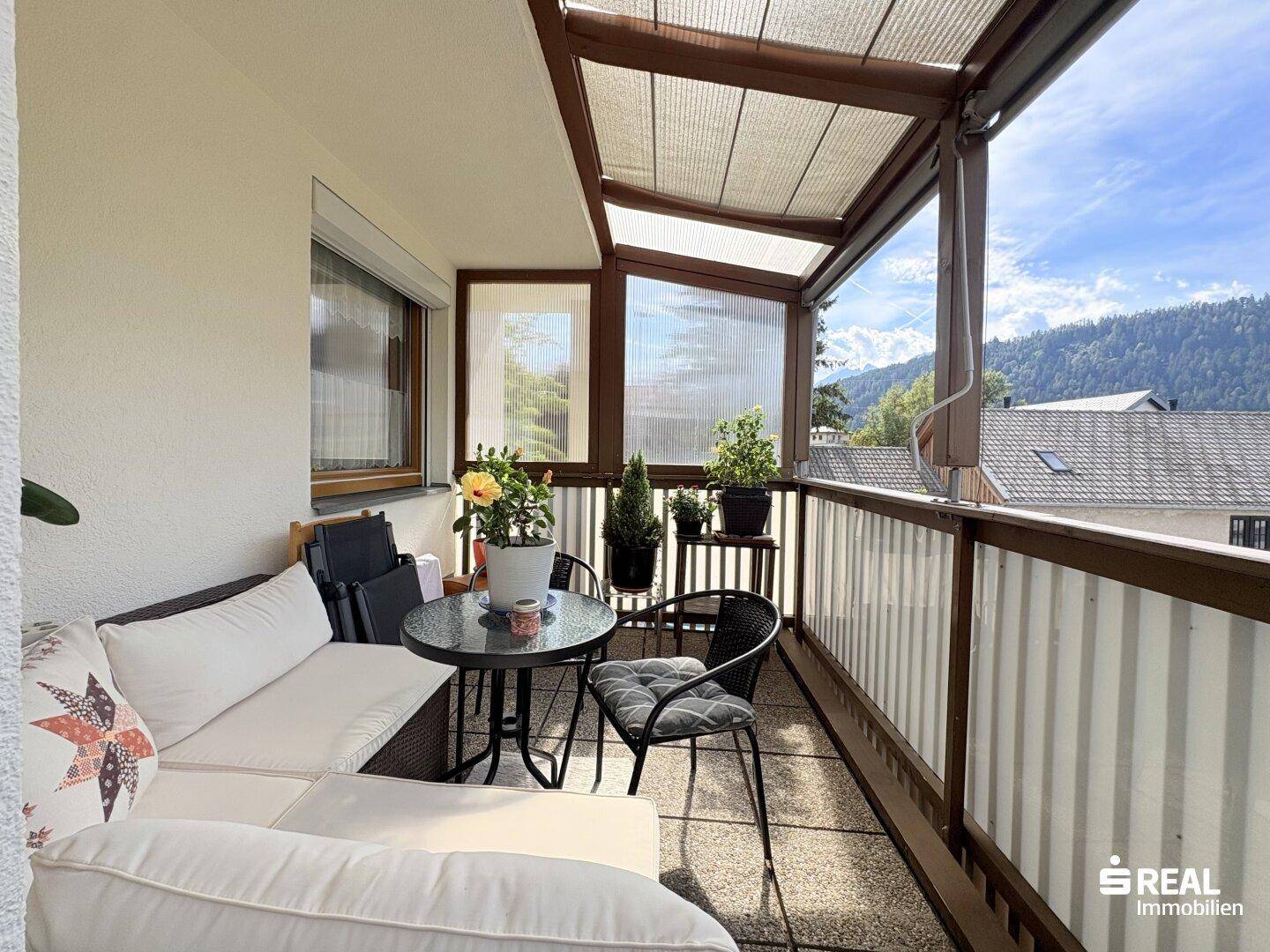 Gemütlicher Balkon mit bequemen Möbeln und Pflanzen, bietet einen schönen Ausblick auf die Umgebung.