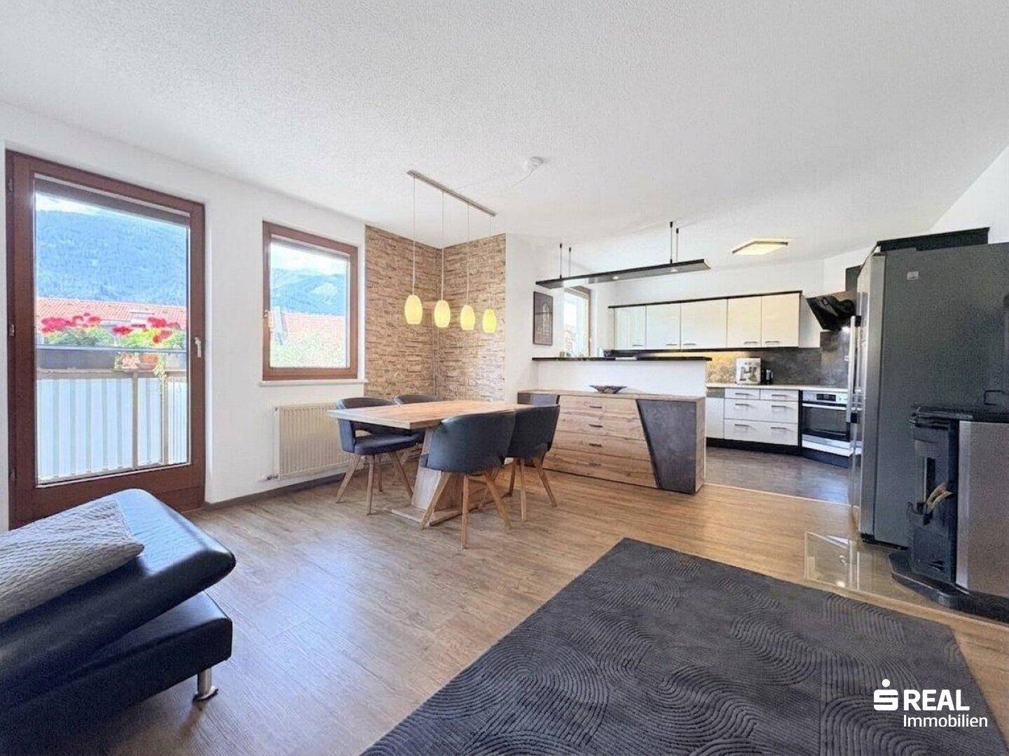 Essbereich mit Holztisch und Stühlen, angrenzend an die moderne Küche, mit Zugang zum Balkon.