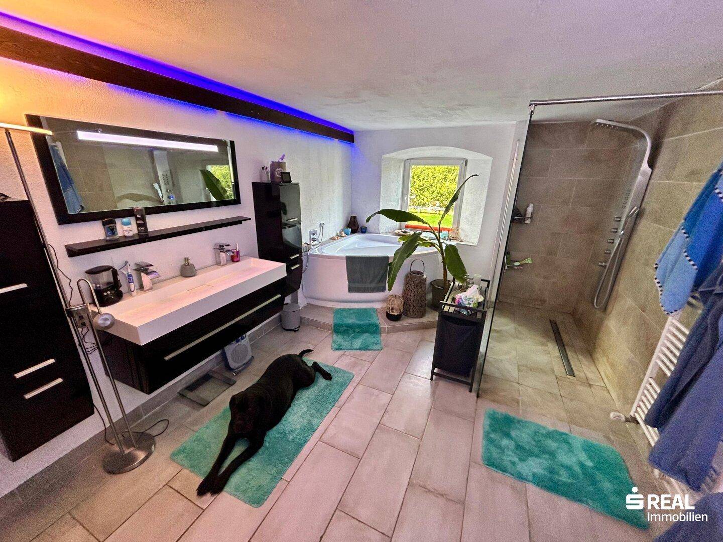 Geräumiges Badezimmer mit Eckbadewanne, ebenerdiger Dusche und Doppelwaschbecken.