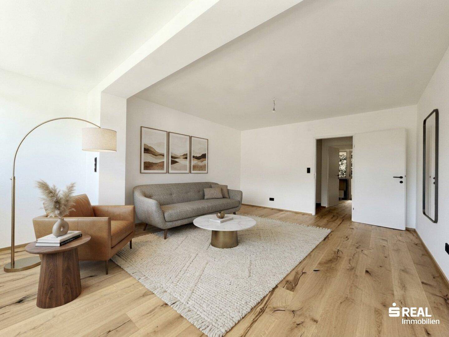 Helles, modern eingerichtetes Wohnzimmer mit Holzboden, beigem Teppich, grauem Sofa und braunem Sessel.