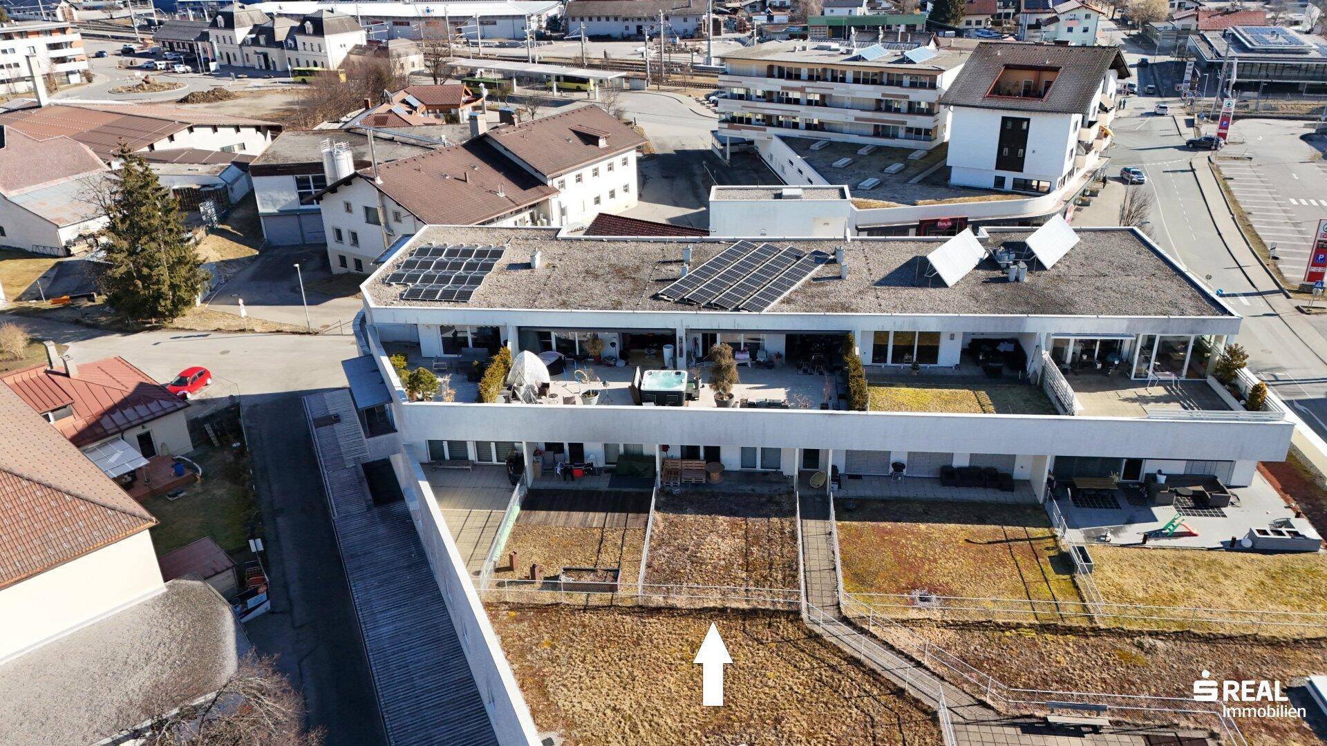 Luftaufnahme des Gebäudes mit Gärten, Terrassen und Solaranlagen auf dem Dach.