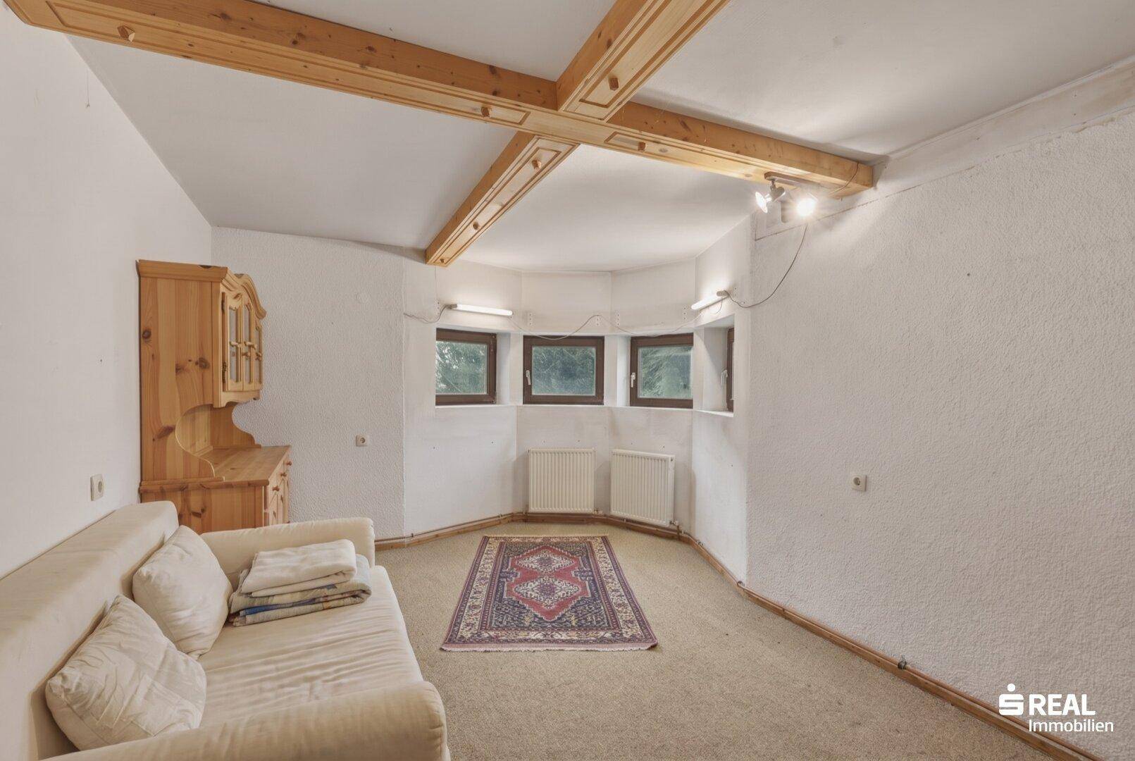 Heller Kellerraum mit Teppichboden, Holzbalken und traditionellem Holzschrank.