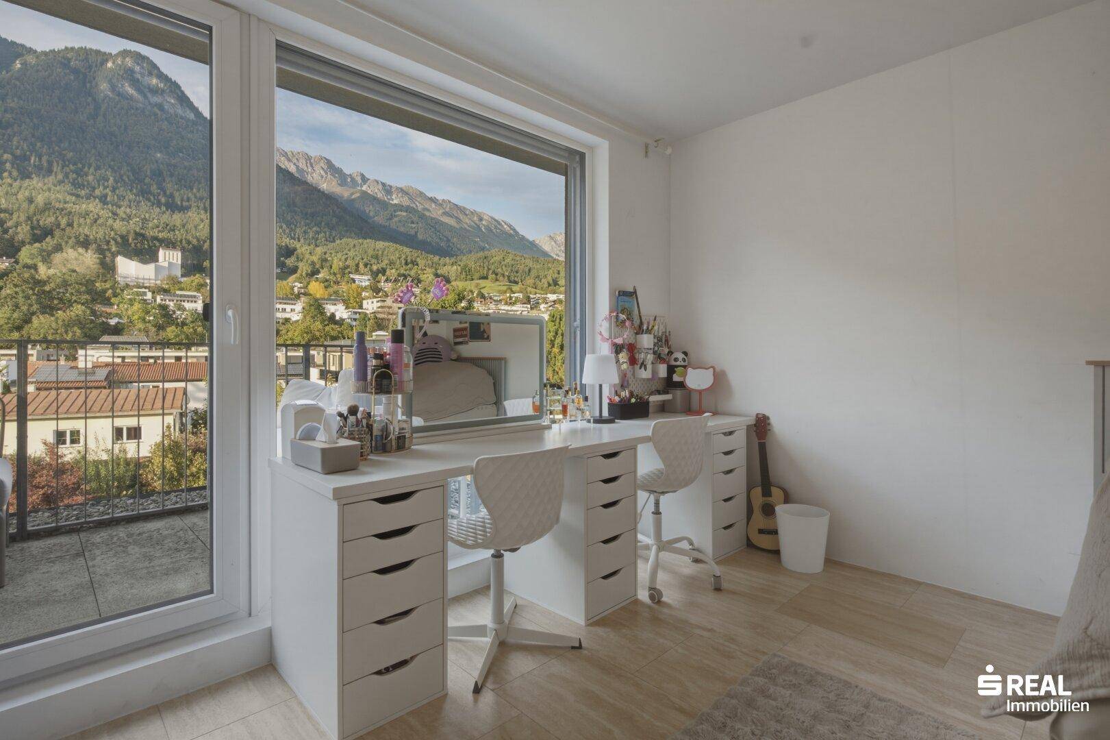 Geräumiges Zimmer mit viel Tageslicht, Bergblick und Zugang zu einem Außenbereich.