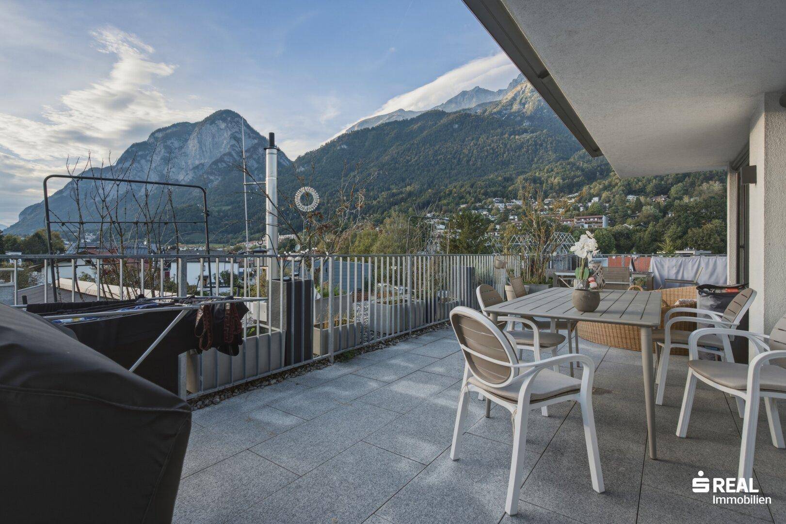 Große Terrasse mit Sitzgelegenheiten und atemberaubendem Panoramablick auf die Berge.