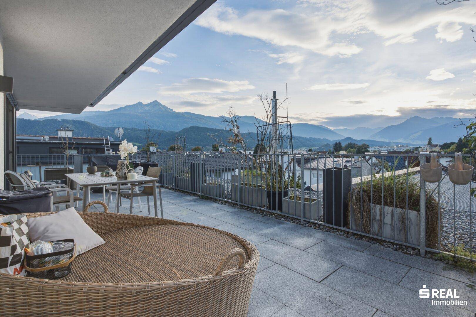 Weitläufige Terrasse mit Lounge-Möbeln und spektakulärem Blick auf die umliegende Berglandschaft.