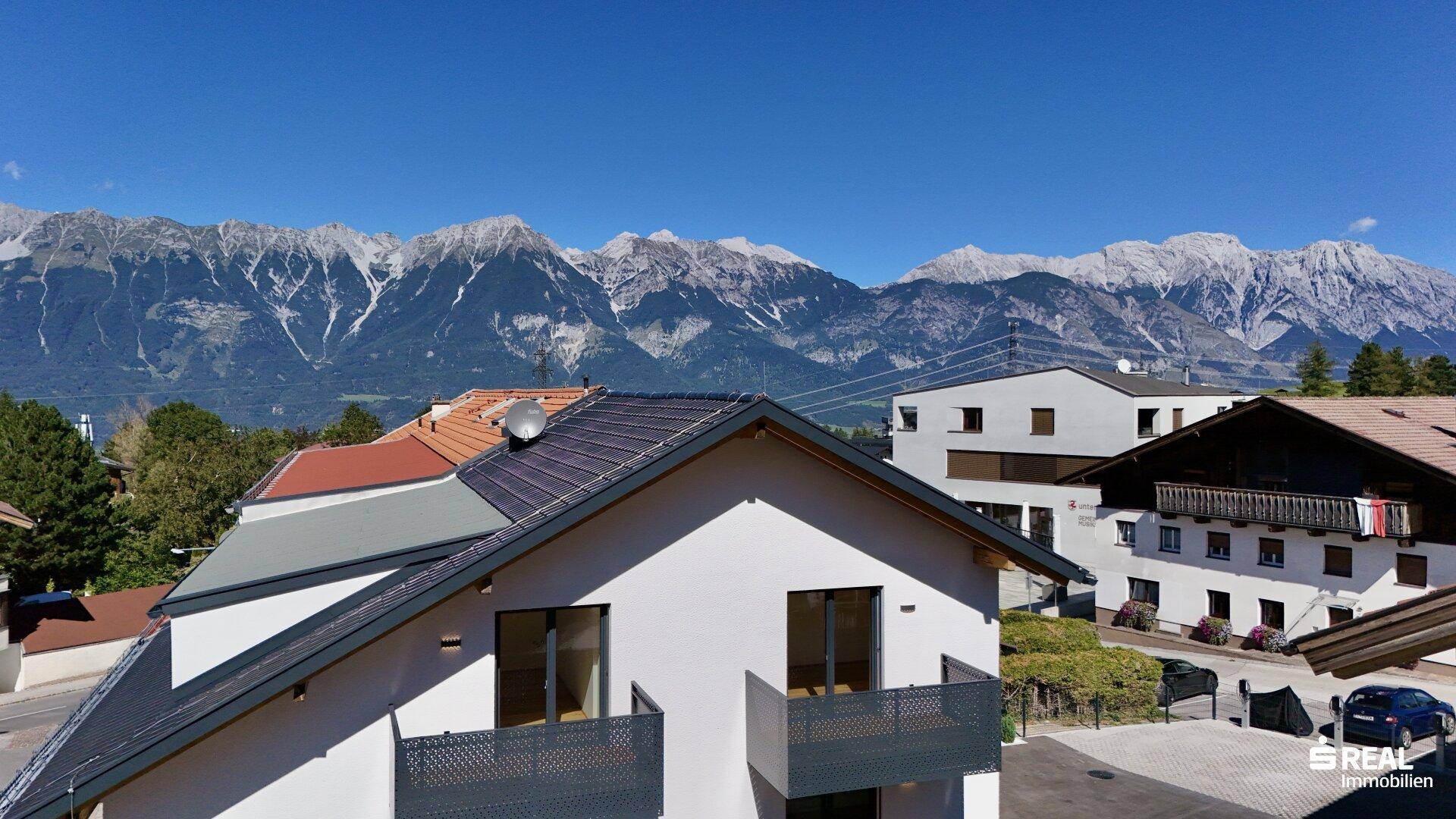 Moderne Wohngebäude mit Balkonen und einem atemberaubenden Blick auf die umliegende Berglandschaft.