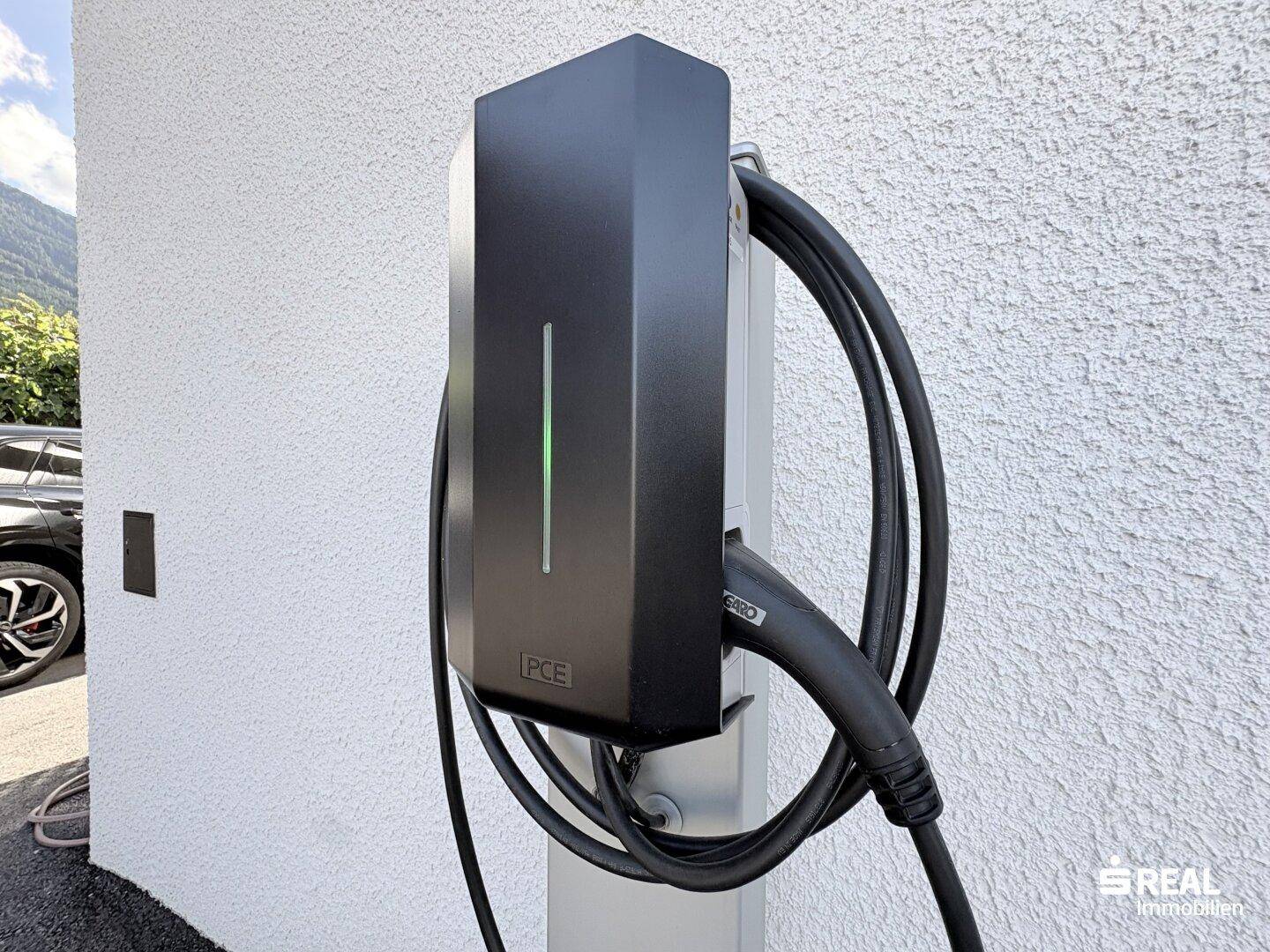 Moderne Ladestation für Elektrofahrzeuge, an der Außenwand des Gebäudes montiert und einsatzbereit.