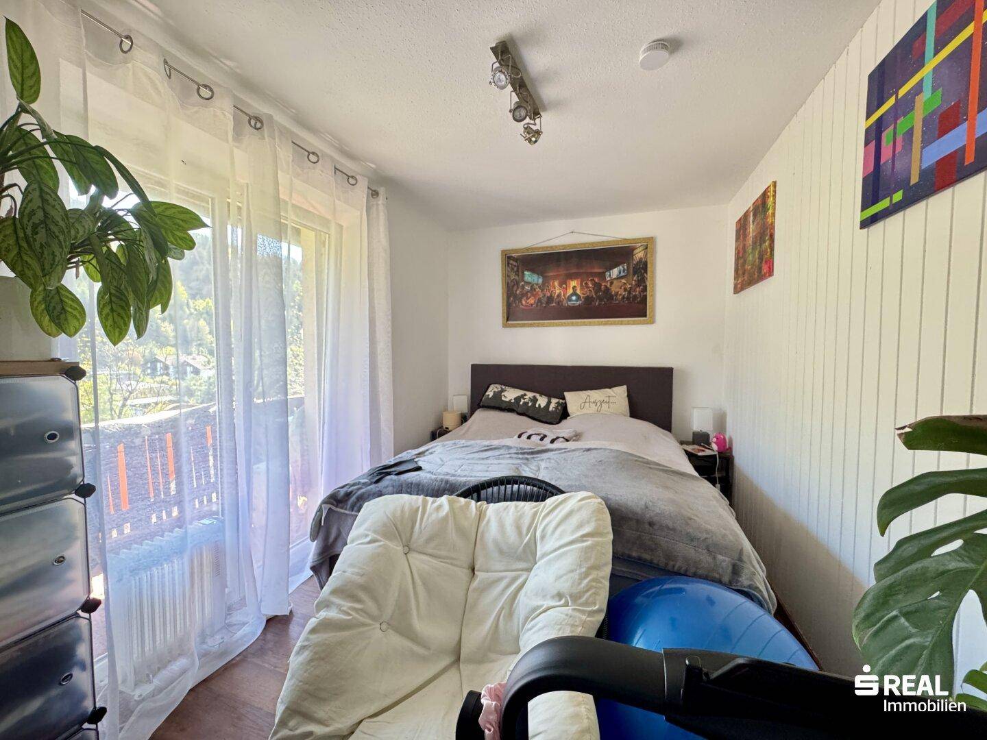 Gemütliches Schlafzimmer mit viel Tageslicht und direktem Zugang zum Balkon.
