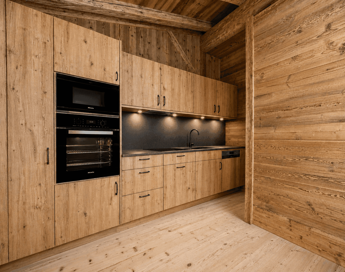 Moderne Holzküche mit integrierten Miele-Geräten und Holzverkleidung im alpinen Stil.