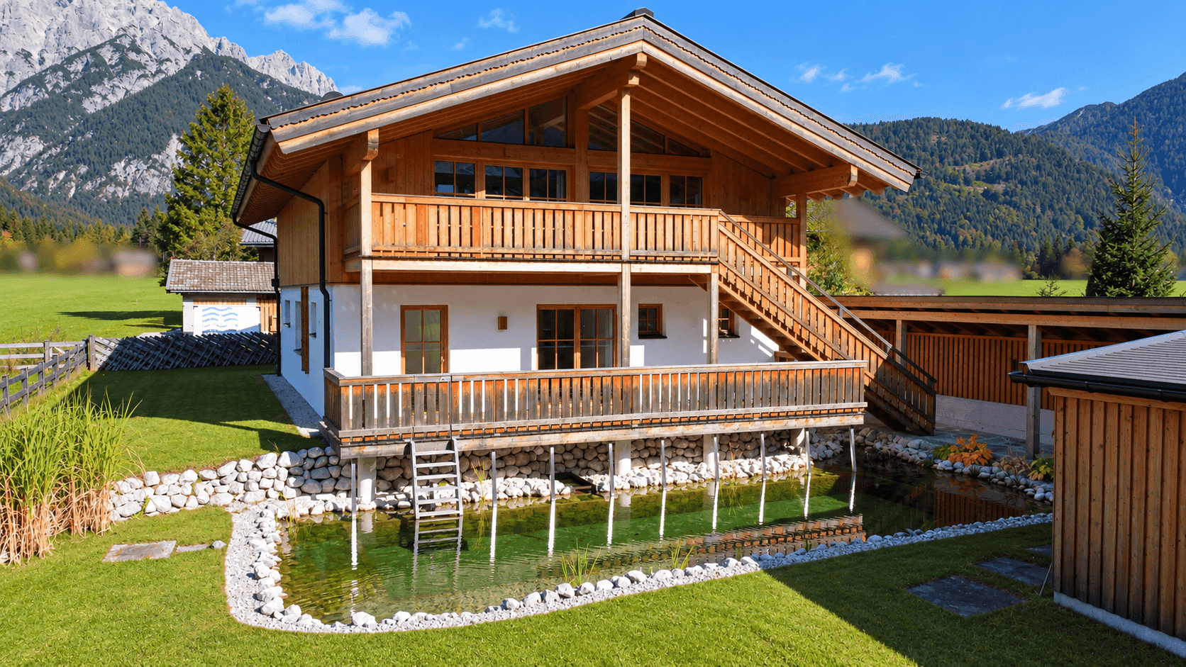 Alpines Holzhaus mit großzügigen Balkonen und einem natürlichen Schwimmteich im Garten.