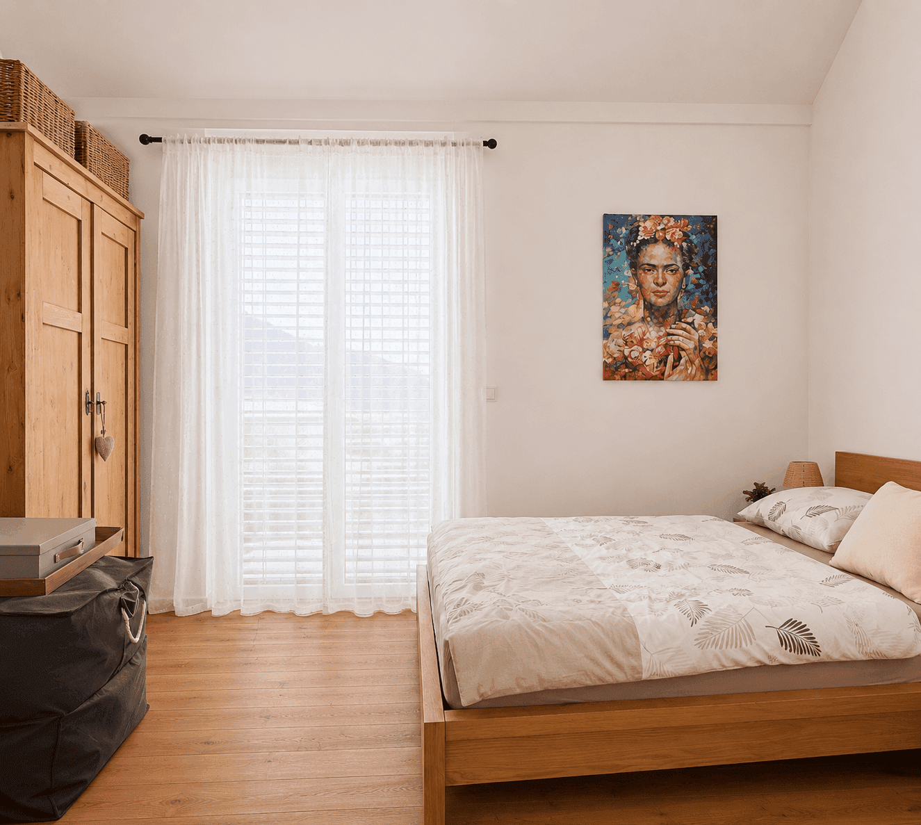 Gemütliches Schlafzimmer mit Holzbett, Holzboden und großem Fenster für viel Tageslicht.