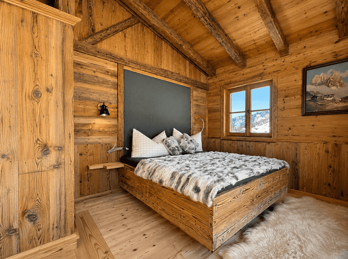 Gemütliches Schlafzimmer im Chalet-Stil mit Holzwänden, Holzbalken und Bergblick.