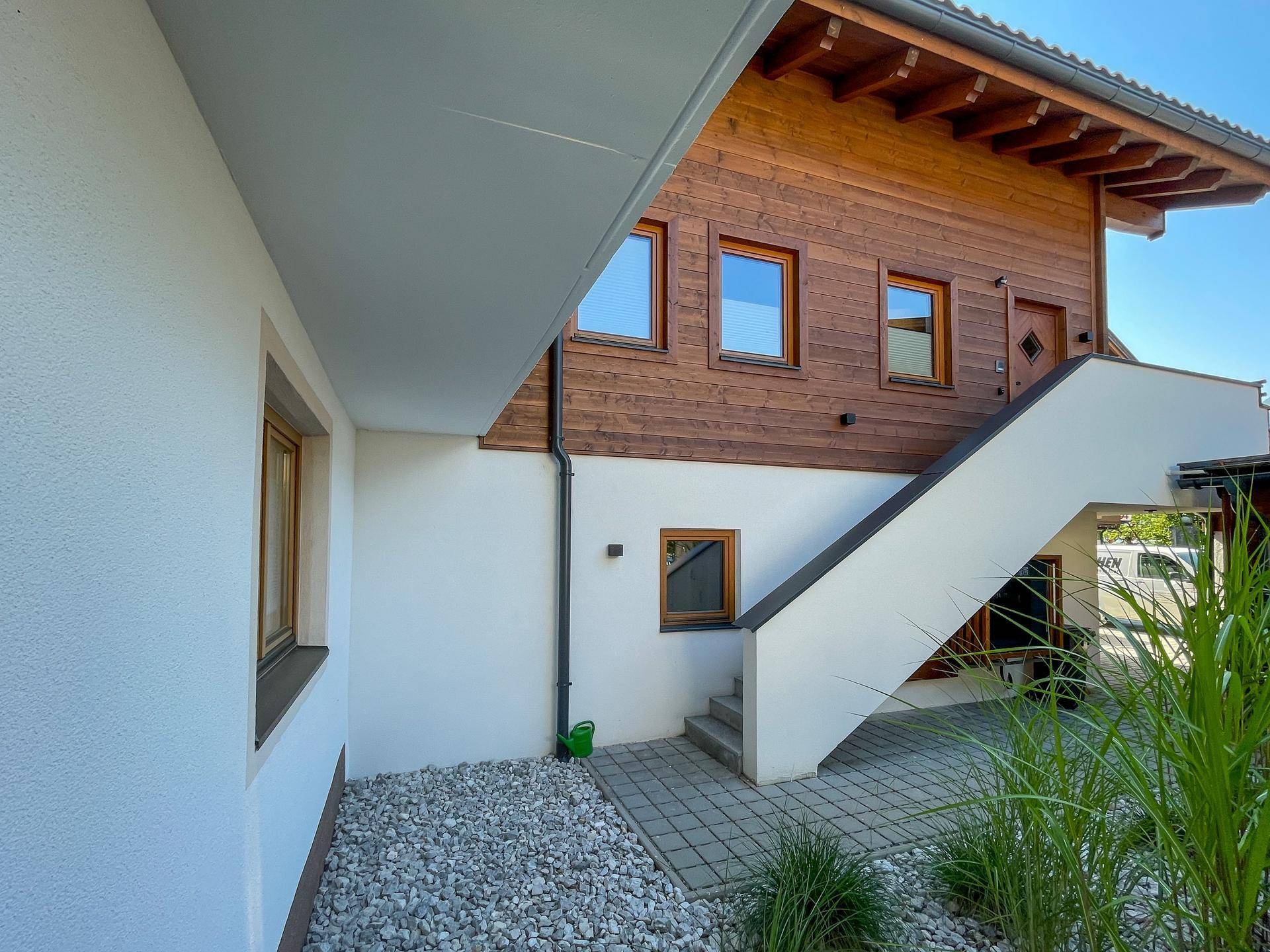 Attraktive Fassade des Gebäudes mit Holzelementen und Außentreppe.