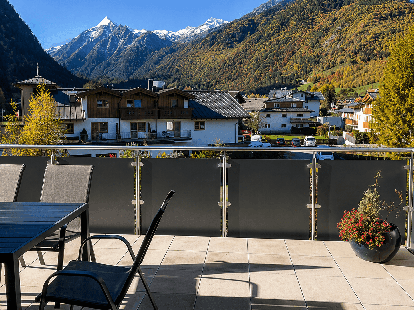 Geräumiger Balkon mit Sitzgelegenheiten und atemberaubendem Blick auf die umliegenden schneebedeckten Berge.