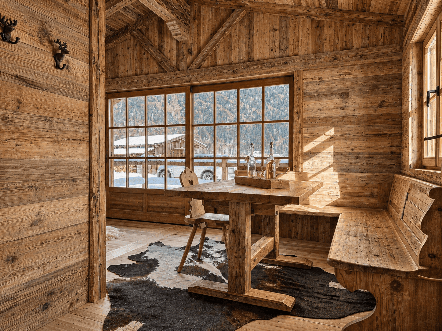 Gemütlicher Essbereich im Chalet-Stil mit Holztisch und Blick auf verschneite Landschaft.