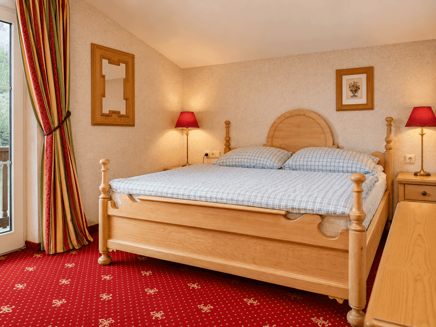 Gemütliches Schlafzimmer mit Holzdoppelbett, rotem Teppich und Zugang zum Balkon.