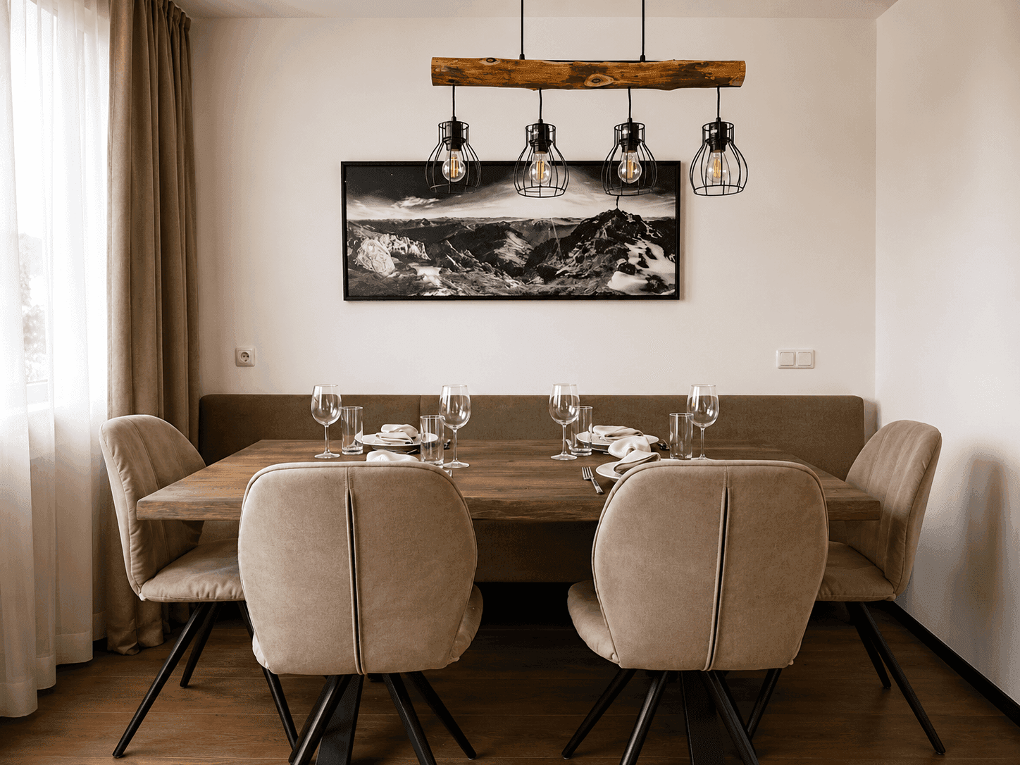 Gemütlicher Essbereich mit Holztisch, bequemer Sitzbank und moderner Hängelampe.