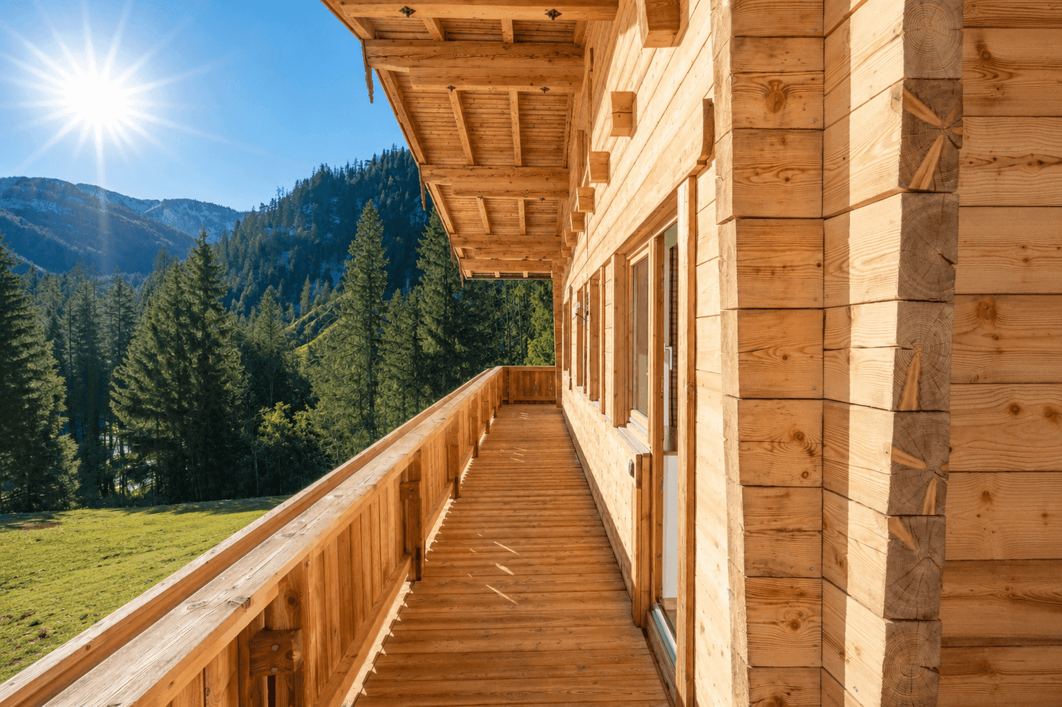 Geräumiger Holzbalkon mit sonnigem Ausblick auf die umliegende Natur und die Berge.