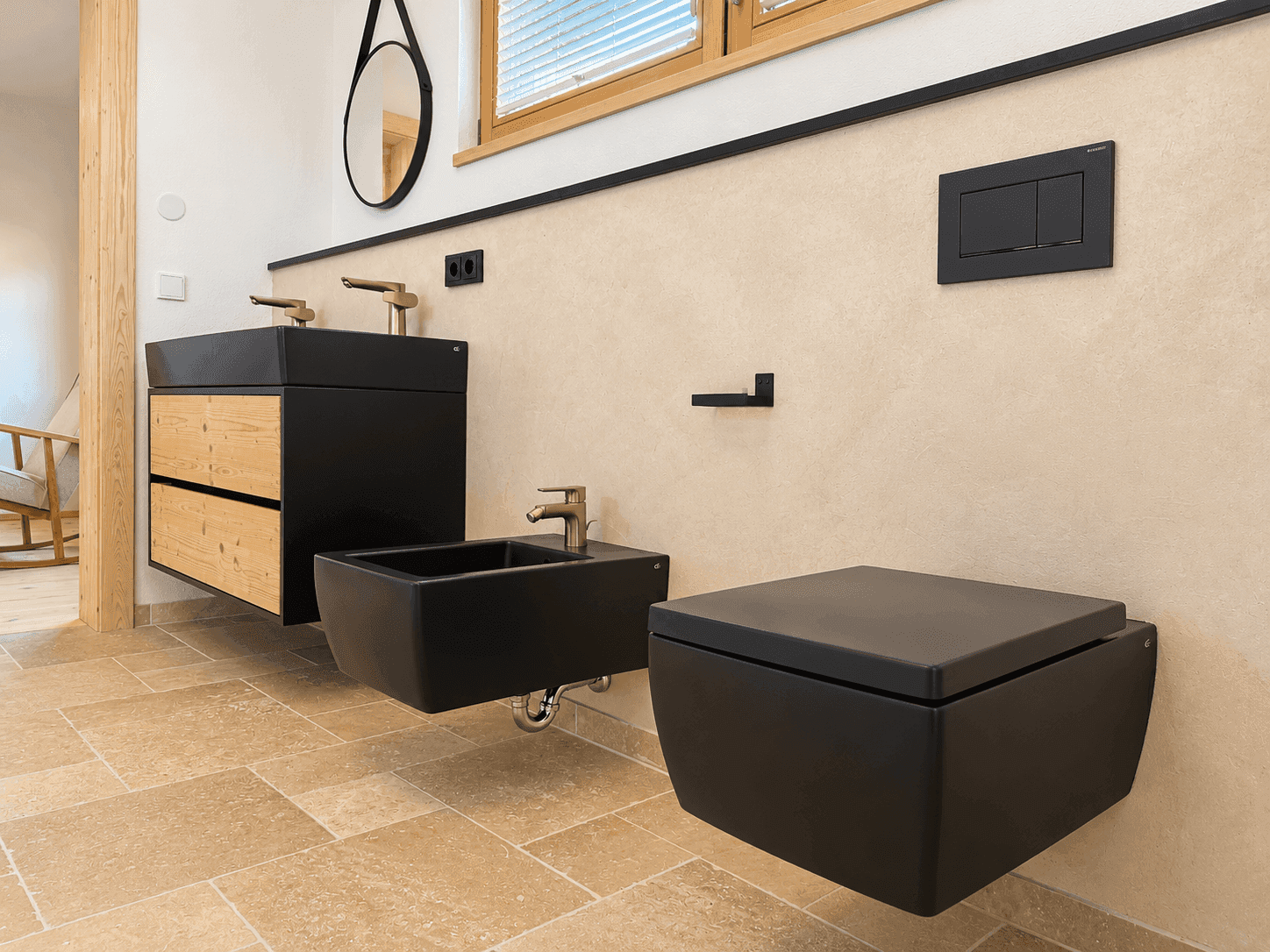 Elegantes Badezimmer mit schwarzem Doppelwaschbecken, Bidet und modernen Armaturen.
