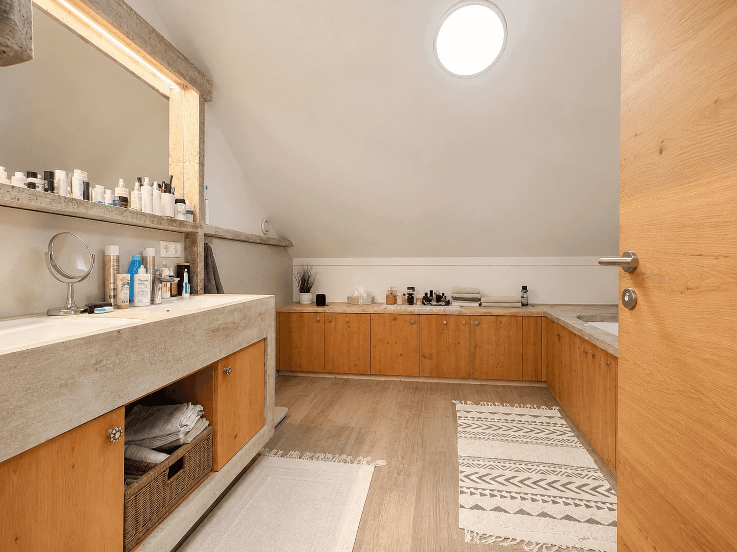 Geräumiges Badezimmer mit Dachschräge, Oberlicht und viel Stauraum unter dem Waschtisch.