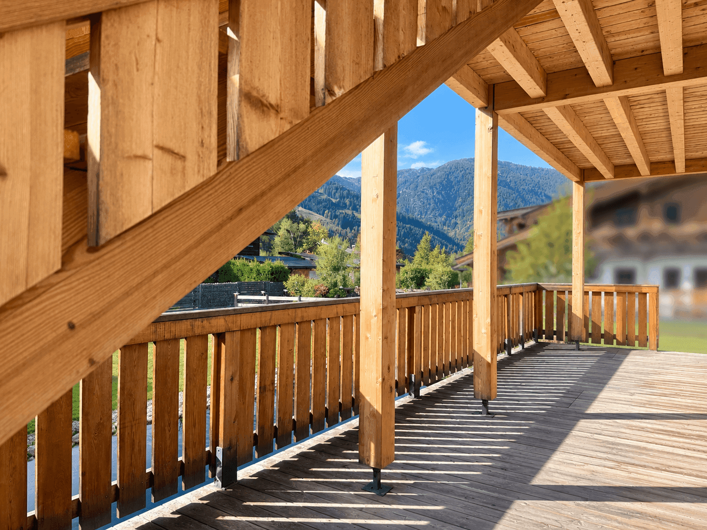Geräumiger Holzbalkon mit Bergblick und viel natürlichem Licht.