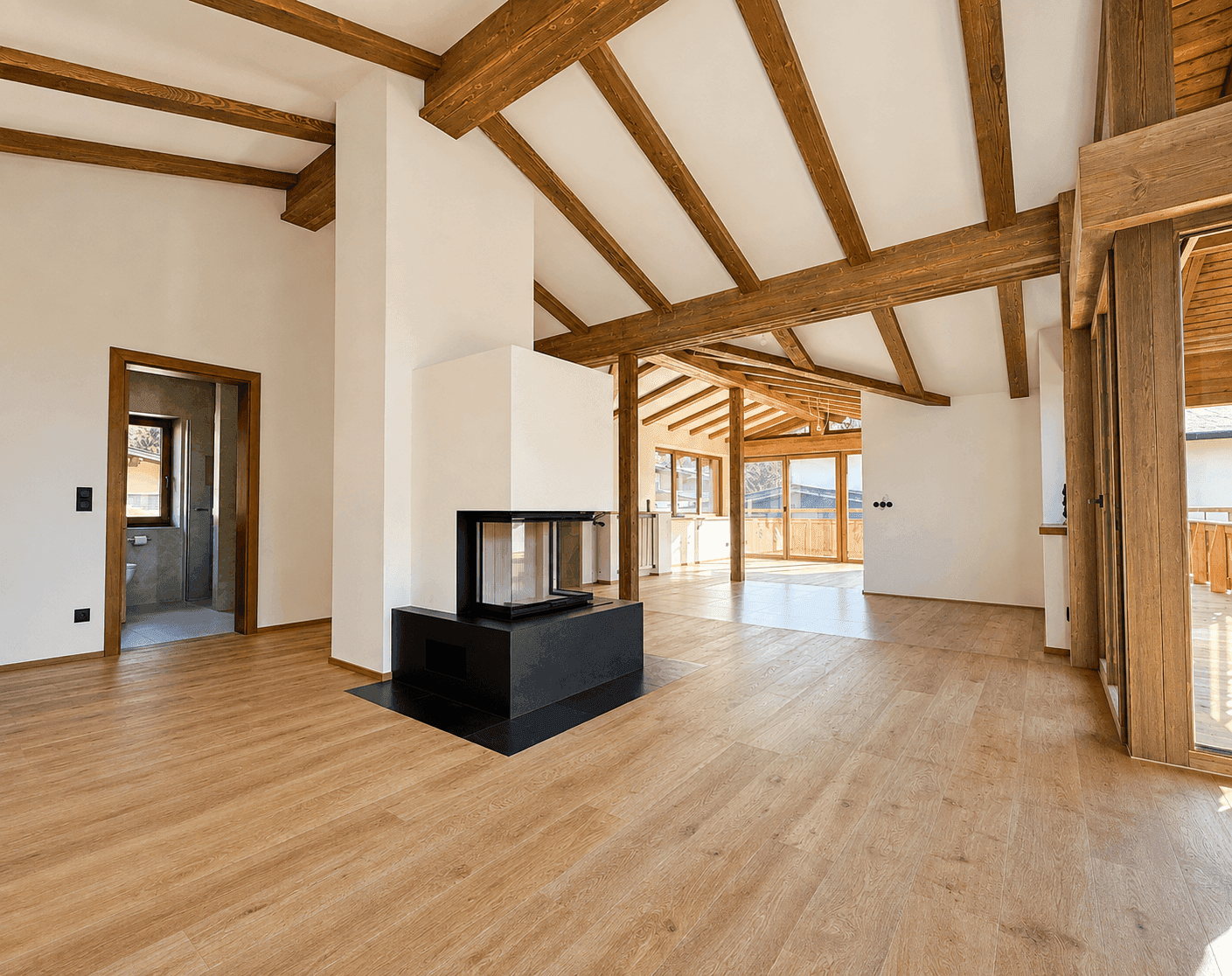 Geräumiges Wohnzimmer mit hohen Decken, sichtbaren Holzbalken und modernem Kamin.
