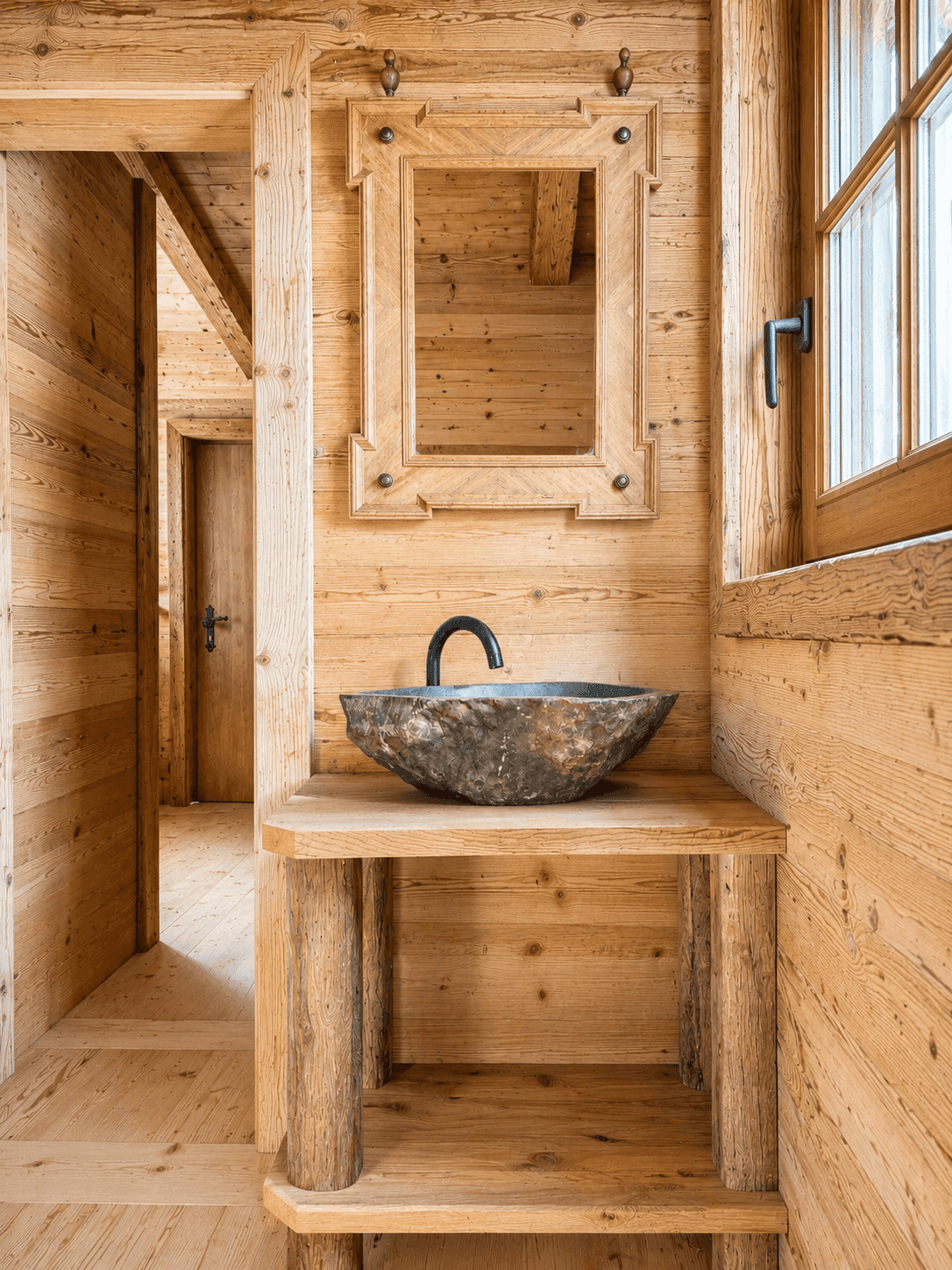 Rustikales Badezimmer mit Holzvertäfelung, Steinwaschbecken und Holzspiegel.