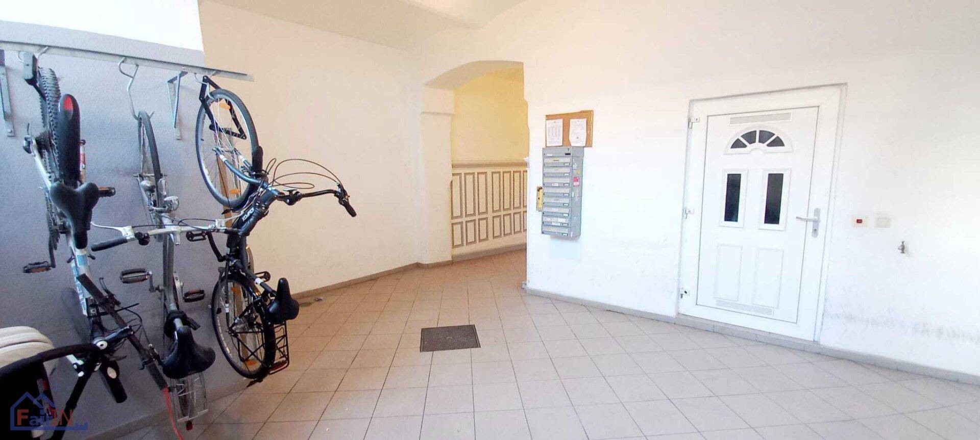 Geräumiger Fahrradraum mit Wandhalterungen und Fliesenboden im Eingangsbereich.