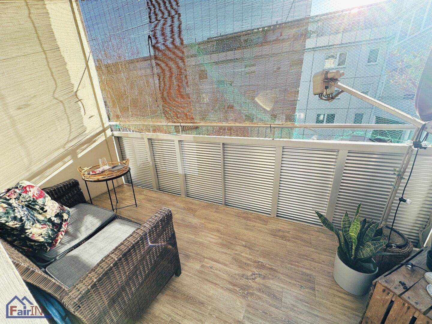 Gemütlicher Balkon mit Sitzgelegenheiten und Blick auf die umliegenden Gebäude.