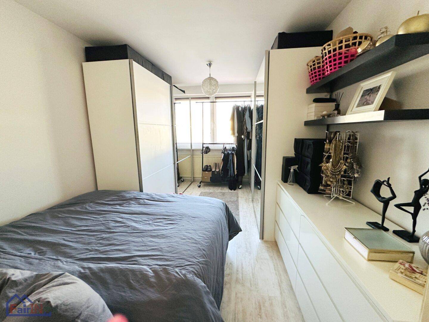 Schlafzimmer mit Doppelbett, Kleiderschränken und Regalen für zusätzlichen Stauraum.