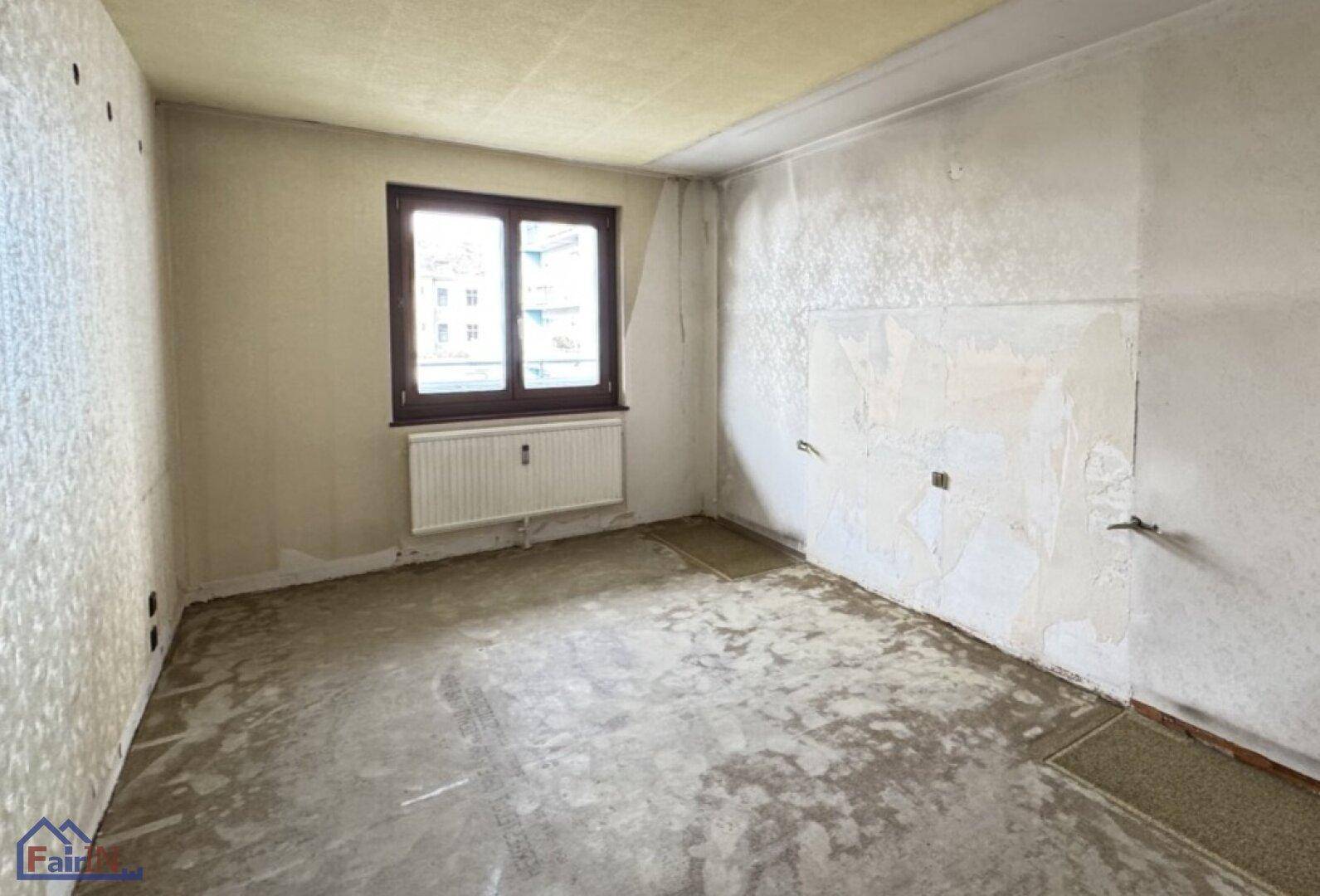 Unmöbliertes Zimmer mit Fenster und rohem Betonboden, ideal für eine individuelle Gestaltung.