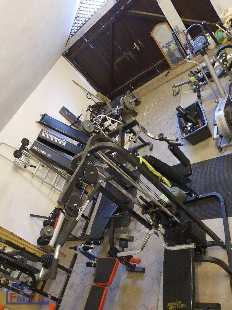 Gut ausgestatteter Fitnessraum mit verschiedenen Trainingsgeräten für das persönliche Workout.