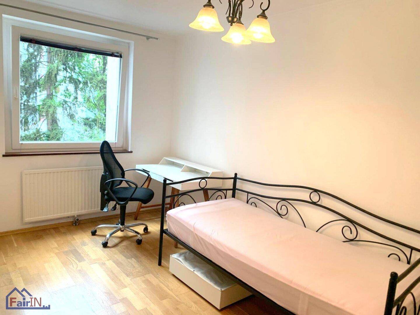Schlafzimmer oder Arbeitszimmer mit Einzelbett, Schreibtisch und Blick ins Grüne.