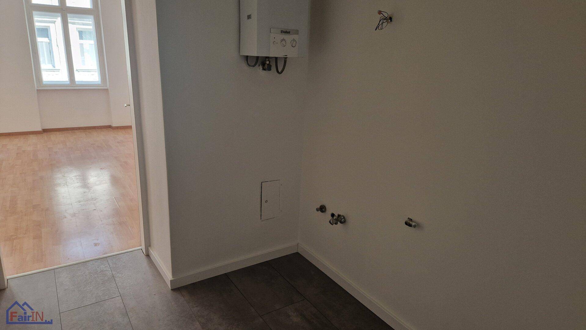 Kleiner Raum mit Fliesenboden, Warmwasserbereiter und Anschlüssen für Sanitäranlagen.