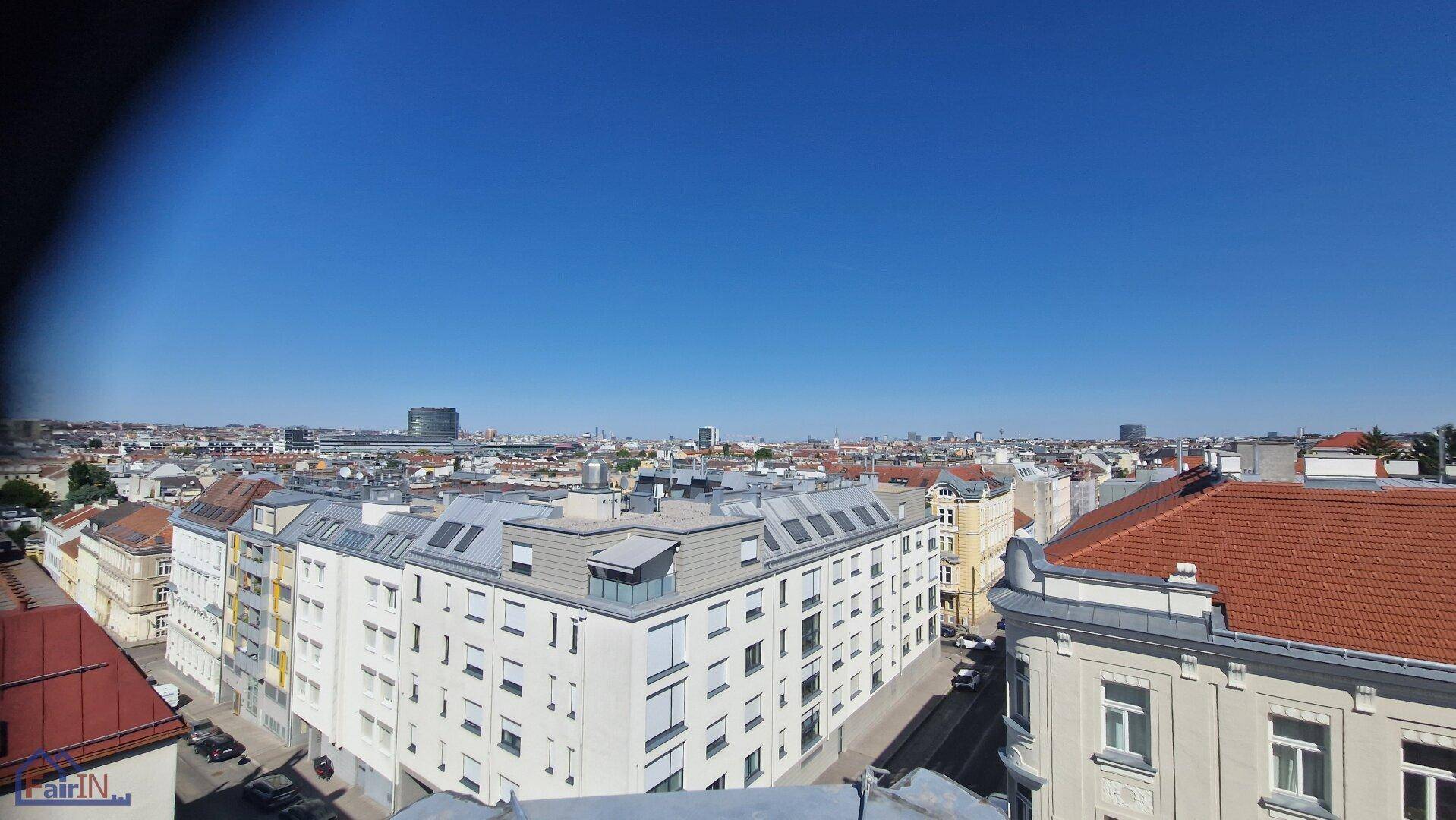 Weitläufiger Panoramablick über die Dächer der Stadt an einem klaren Tag.