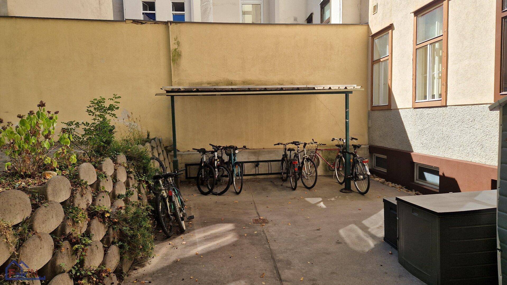Innenhof mit Fahrradabstellplatz und einer kleinen Grünfläche.