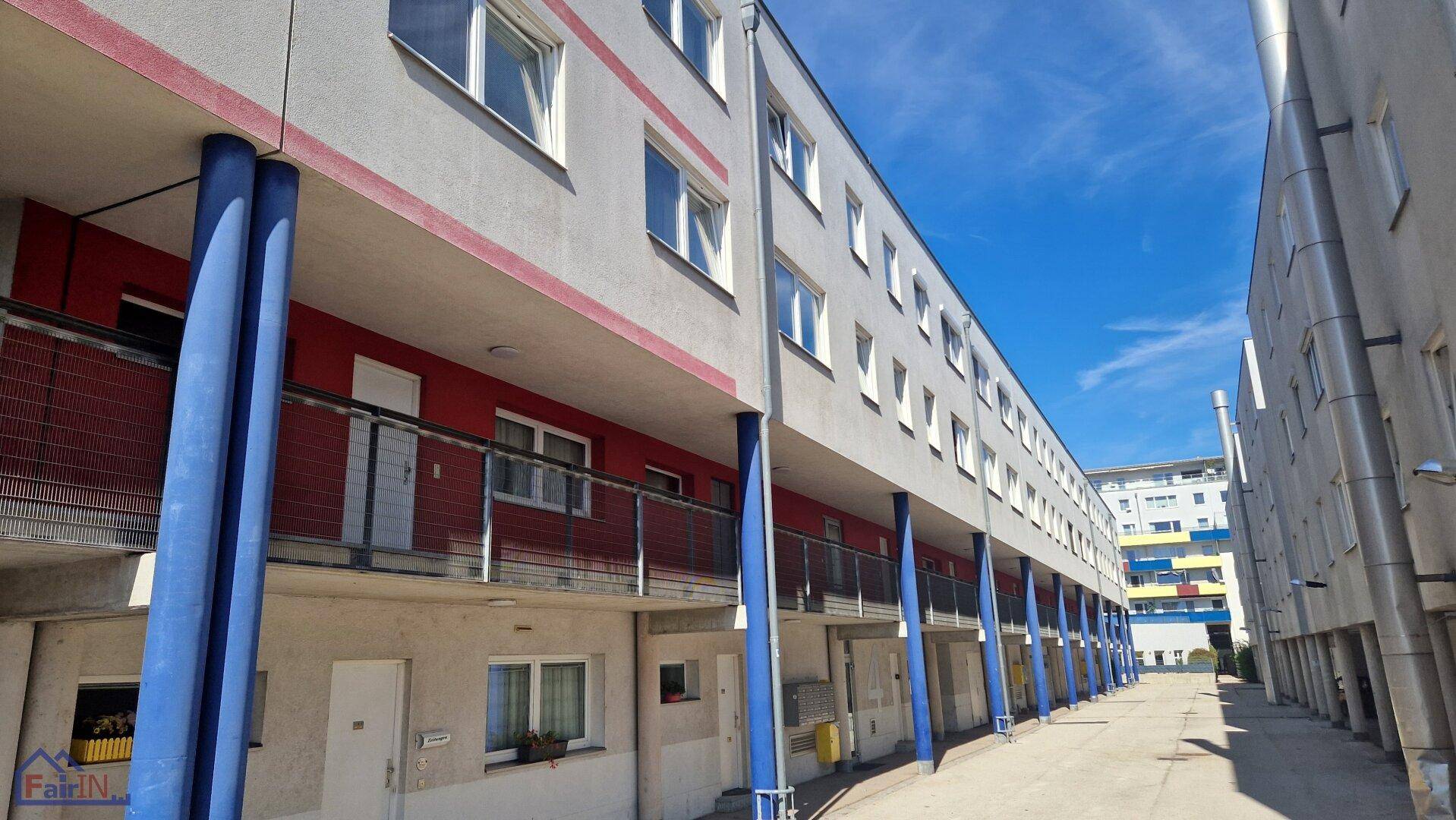 Moderne Wohnanlage mit farbigen Akzenten und Balkonen, die eine lebendige Fassade bilden.