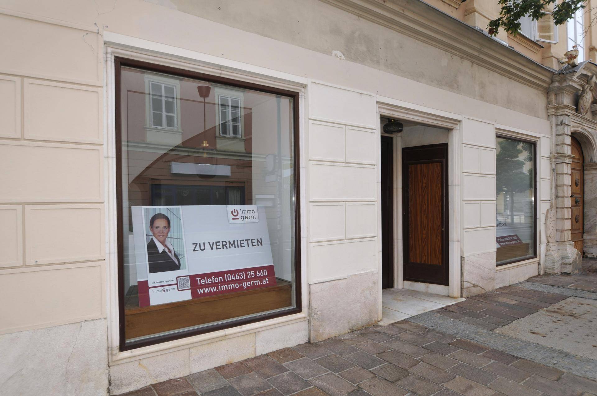 Schaufenster des Erdgeschosses mit einer 'Zu vermieten'-Anzeige und Blick auf die Straße.