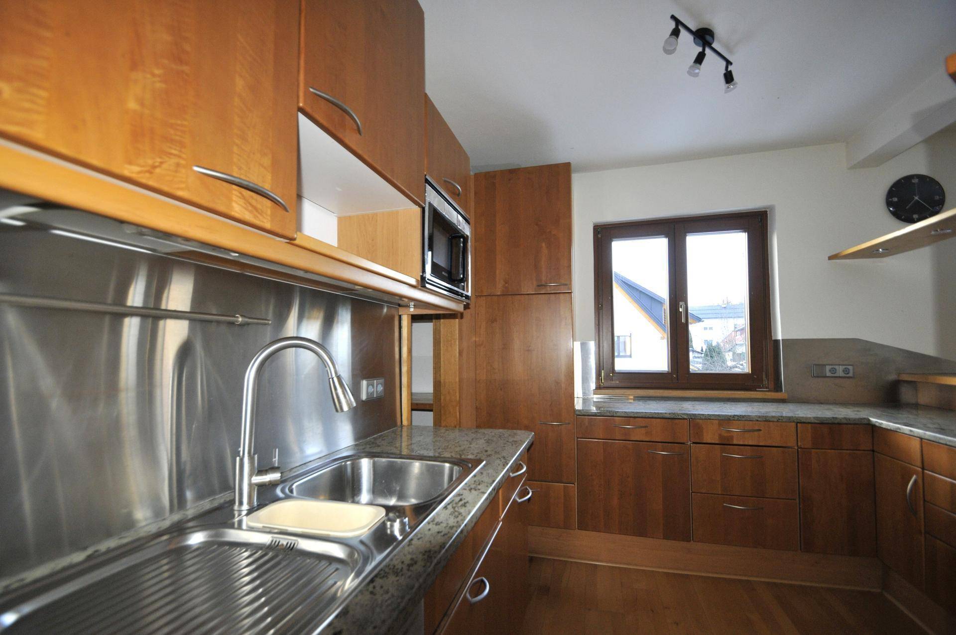 Traditionelle Holzküche mit Granitarbeitsplatten, Edelstahlrückwand und Doppelspüle.
