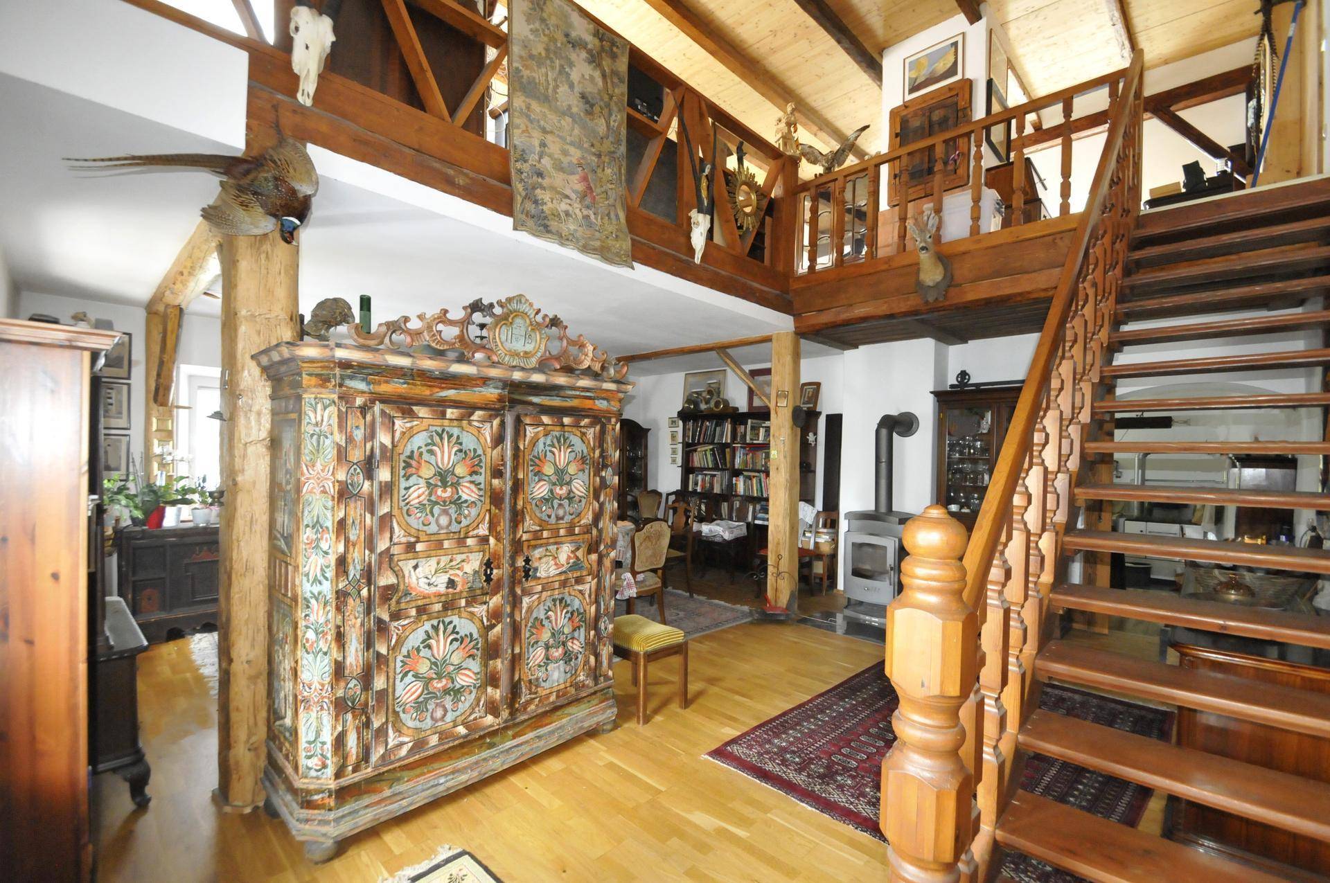 Rustikaler Wohnbereich mit hohen Holzdecken, offener Galerie und traditionellen Möbeln.