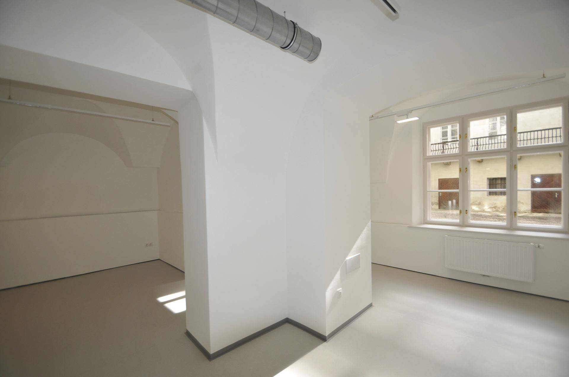 Gewerberaum mit großem Fenster, das einen Blick auf einen Innenhof oder eine Gasse bietet.