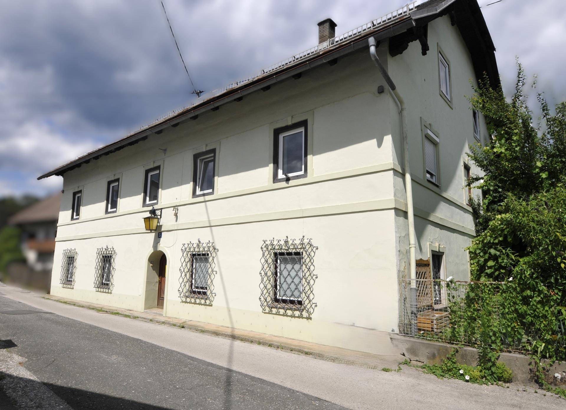 Traditionelle Fassade eines historischen Gebäudes mit dekorativen Fenstergittern und Laterne.