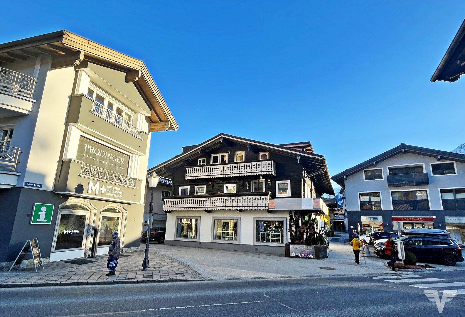 Blick auf die belebte Straße mit traditionellen Gebäuden und Geschäften unter blauem Himmel.