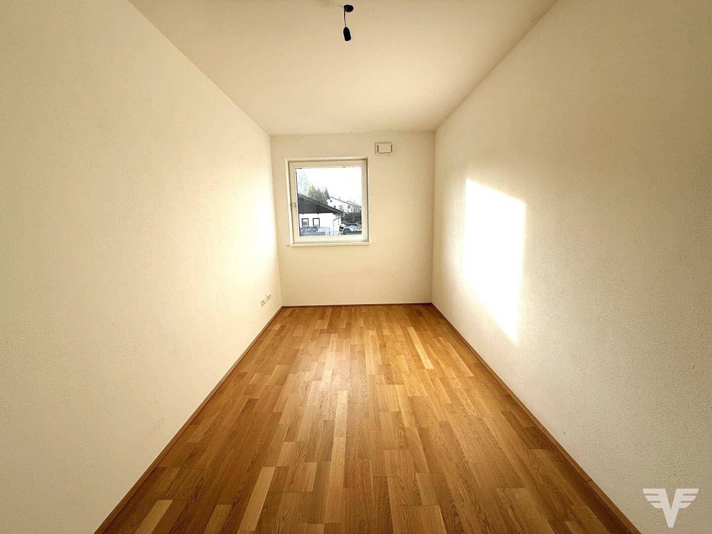 Freundliches Zimmer mit Holzboden und Fenster, das sich gut als Schlaf- oder Arbeitszimmer eignet.