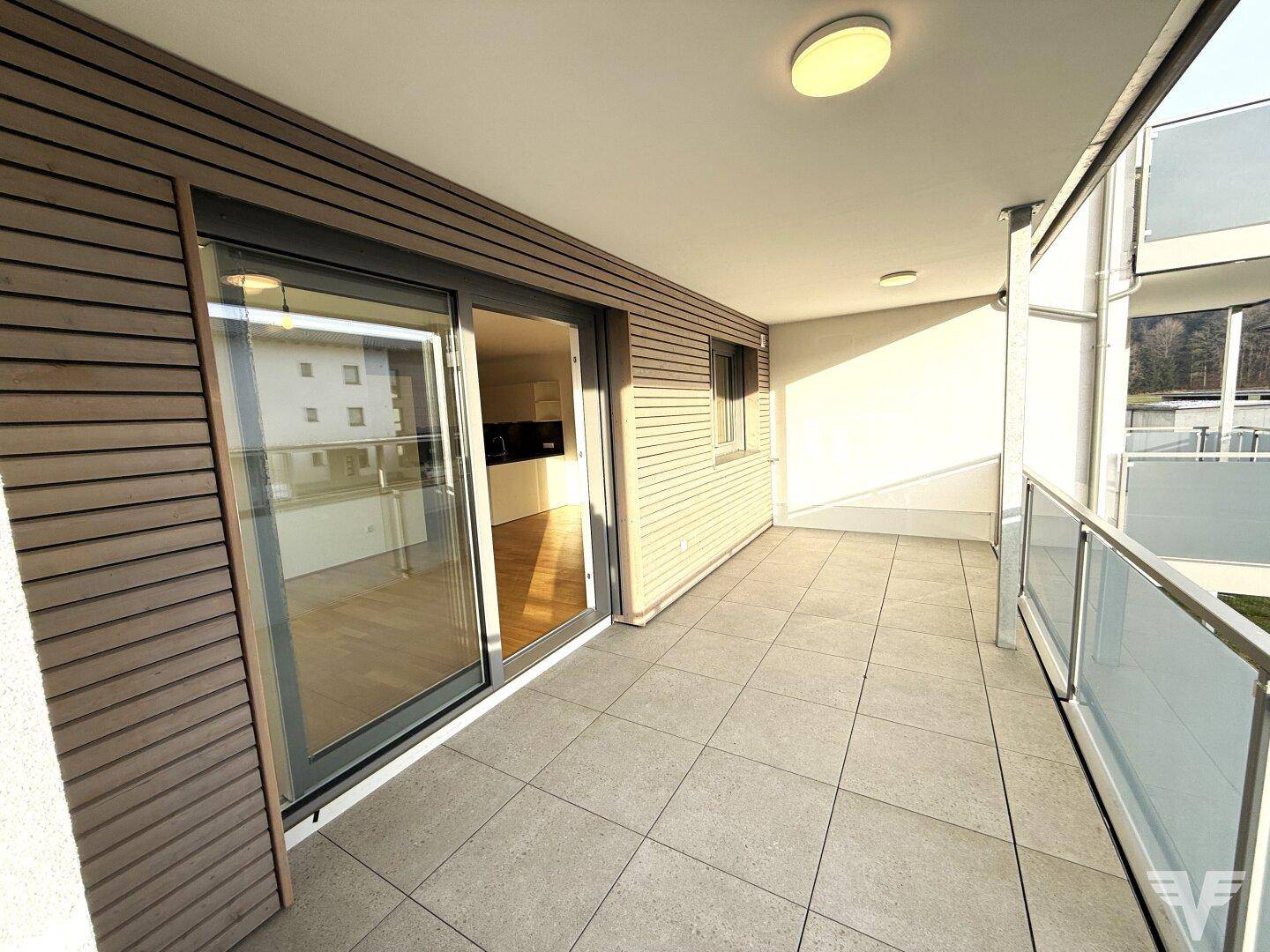 Geräumiger Balkon mit Fliesenboden und Holzverkleidung, ideal für entspannte Stunden im Freien.