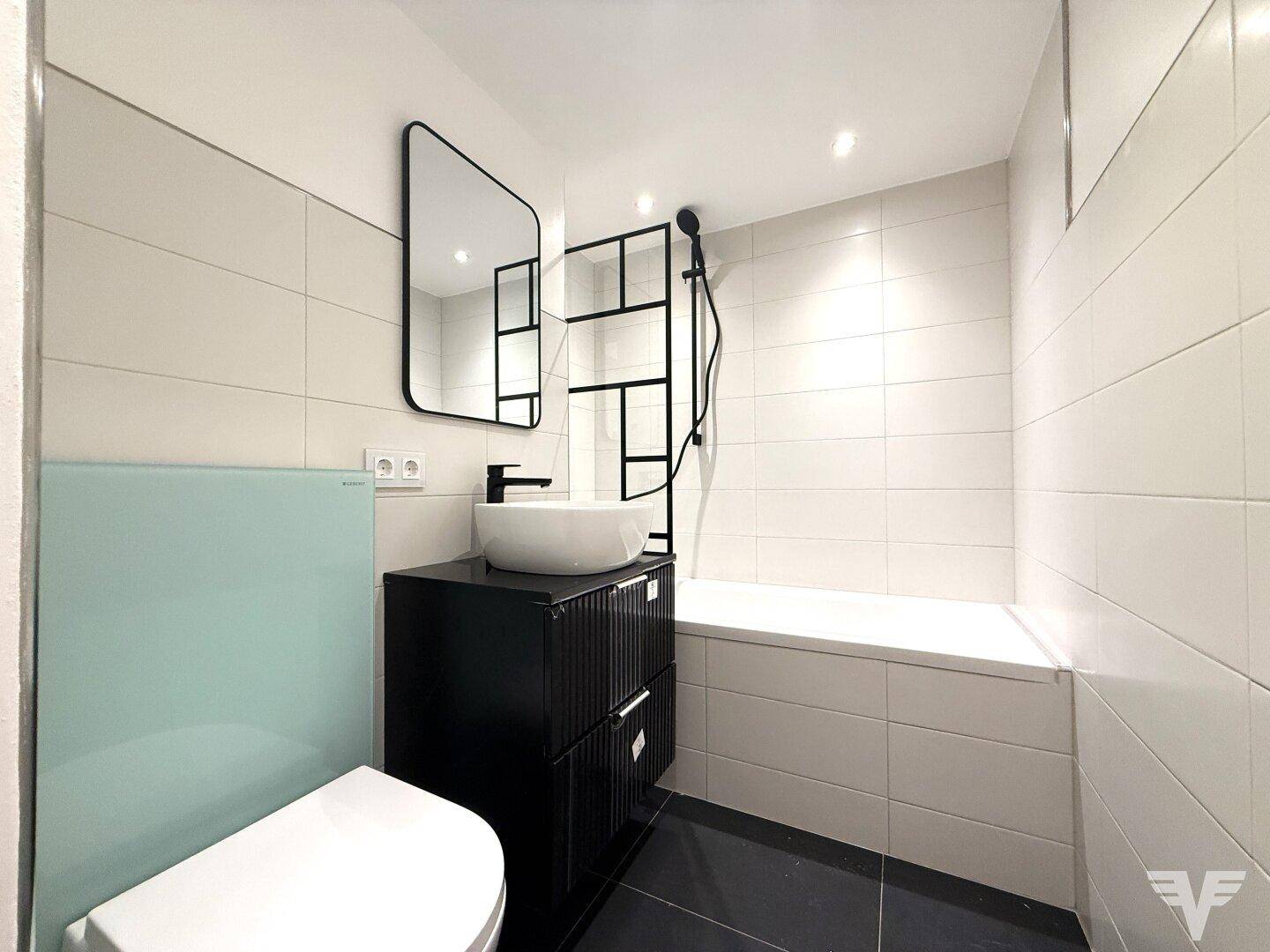 Modernes Badezimmer mit Badewanne, wandhängendem WC und stilvollem Waschtisch.