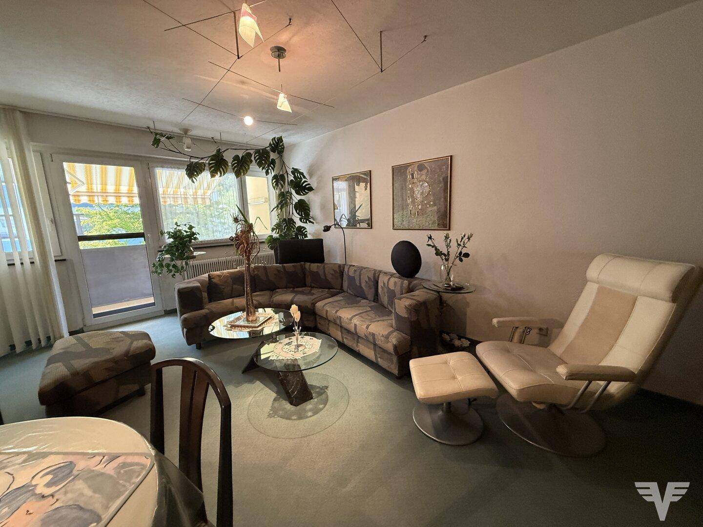 Heller Wohn-Essbereich mit Zugang zum Balkon und gemütlicher Sitzecke.