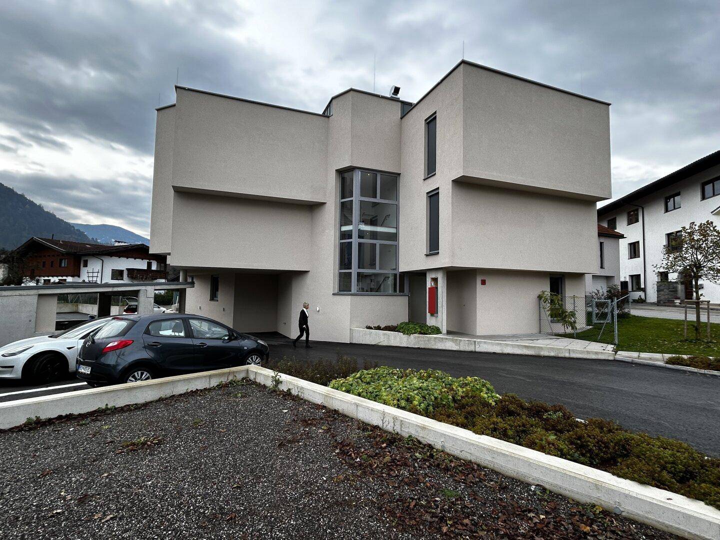 Gesamtansicht des modernen Mehrfamilienhauses mit markanter Architektur und Eingangsbereich.