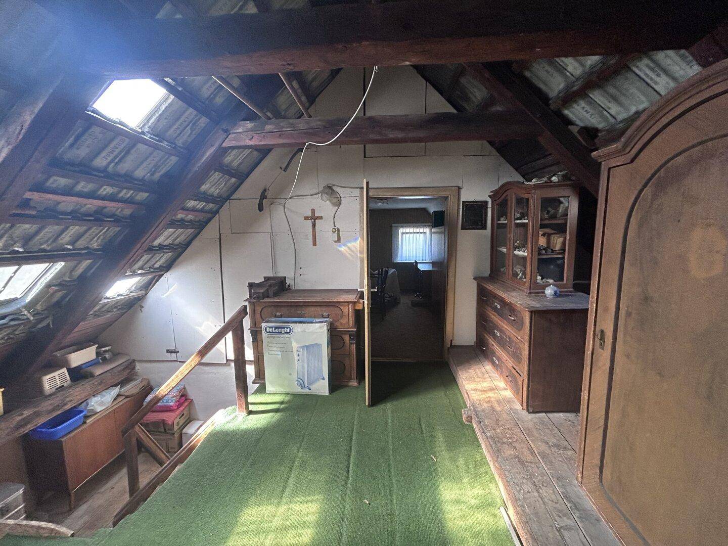 Geräumiger Dachboden mit sichtbaren Holzbalken, Dachfenstern und viel Stauraum.